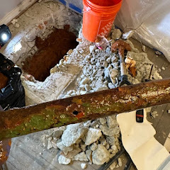 Corroded pipe exposed through concrete slab for replacement