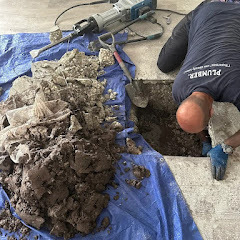 Technician excavating concrete slab to access leak